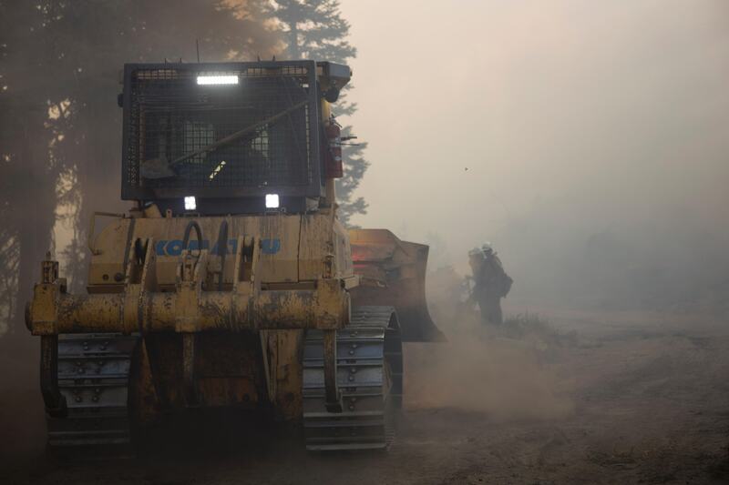 A dozer and firefighters on the fireline in smoke, Pioneer Fire, Boise National Forest, Idaho, 2016
